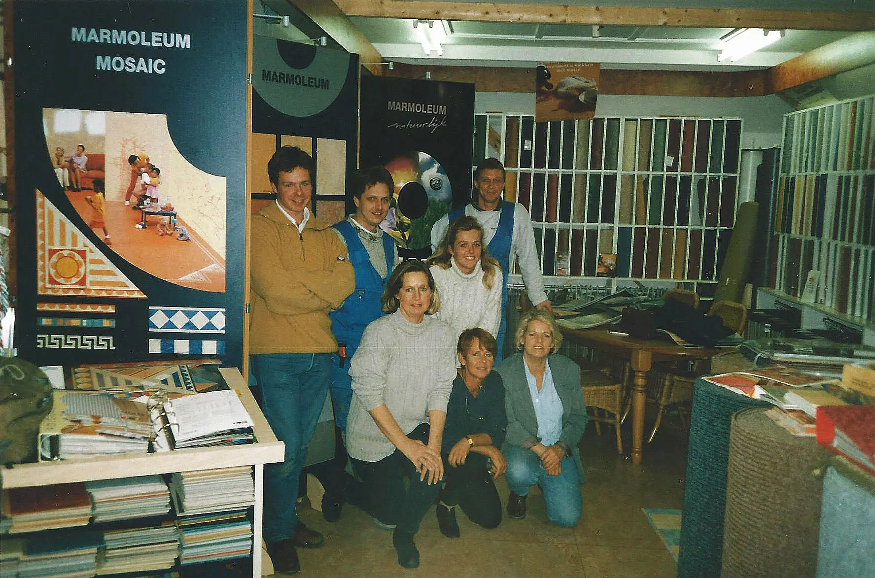 Het team van Smid Interieur in de showroom van weleer, temidden van Marmoleum-stalen en tapijtmonsters